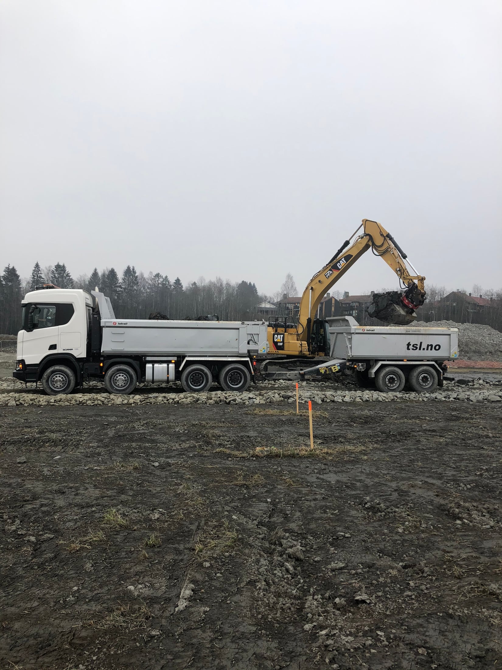 Gravemaskin laster steinmasser på lastebil ved Byporten Jessheim