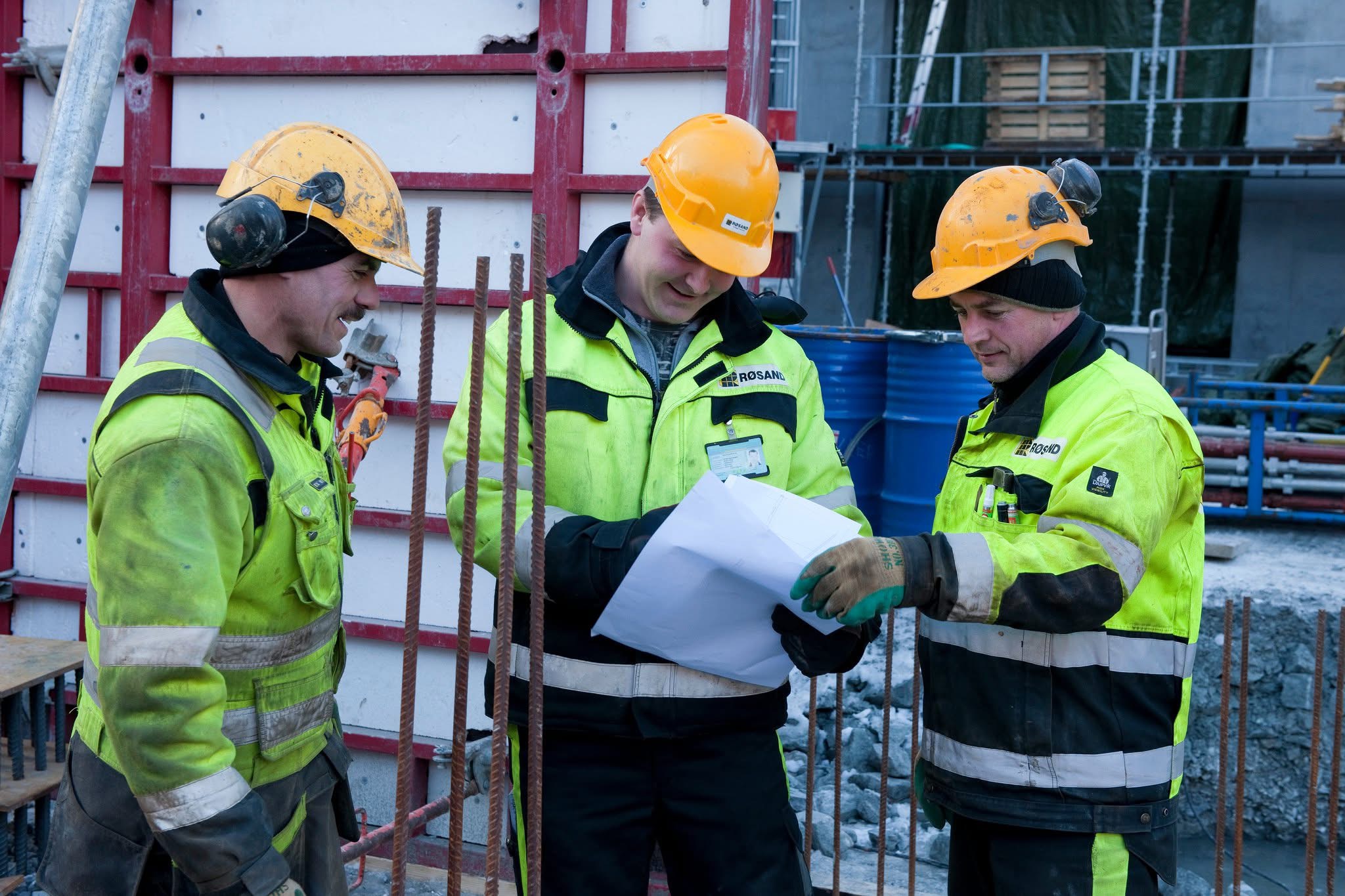 Pawel, Bengt-Arne Jørgensen og Mierek studerer en tegning på byggeplassen
